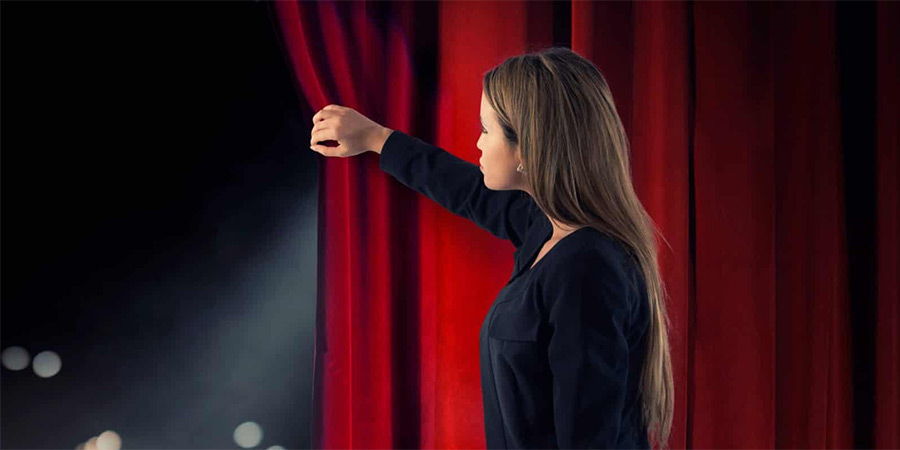 Woman looking out from behind a curtain Woman looking out from behind a curtain