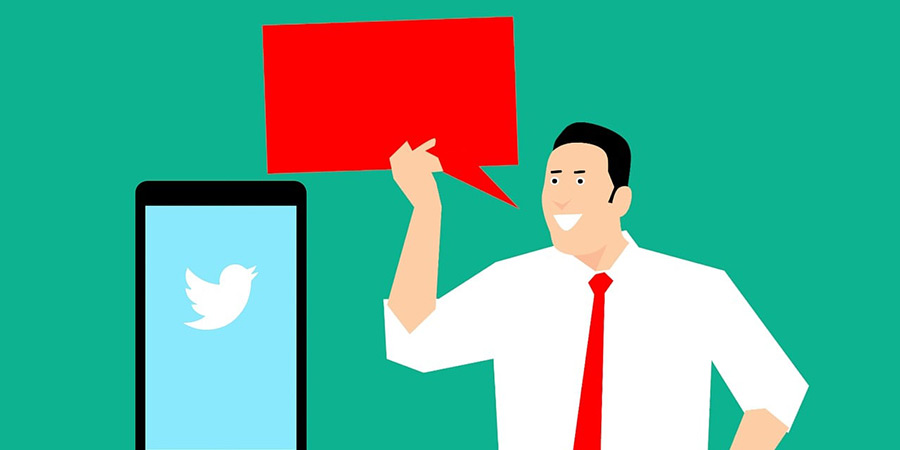 Man holding a speech bubble near a phone with Twitter logo on