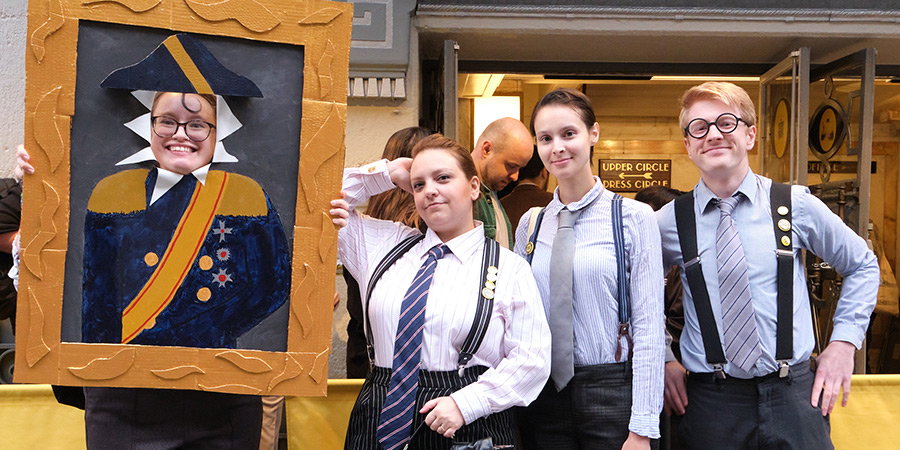 Cosplayers dressed up in business suits outside a theatre