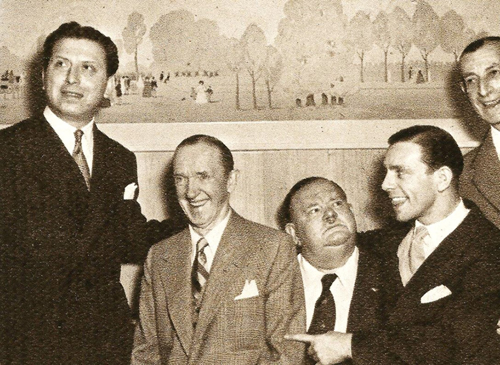 Image shows left to right: Bernard Delfont, Stan Laurel, Oliver Hardy, Norman Wisdom