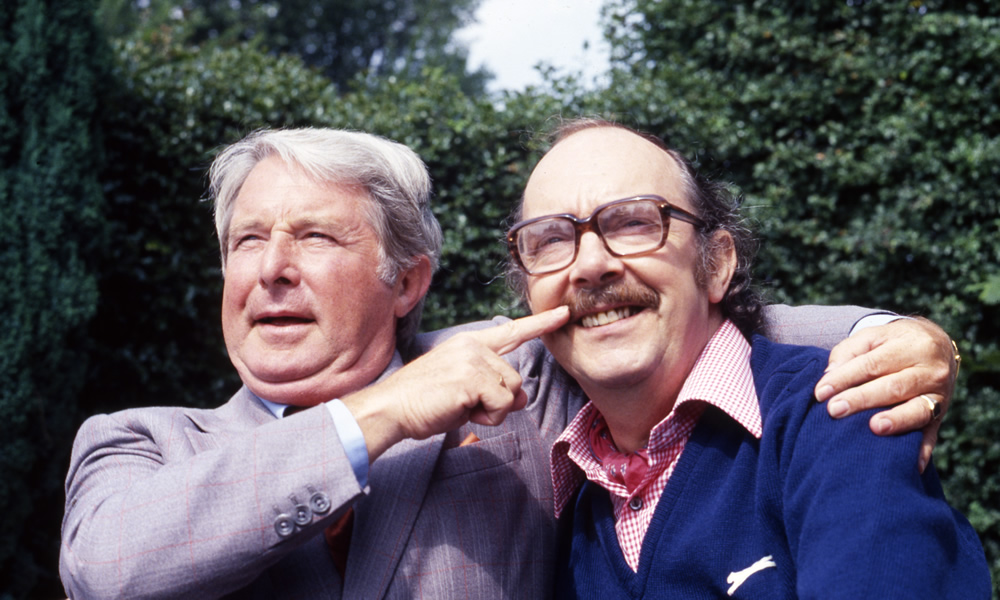 Eric Morecambe and Ernie Wise in the garden of Eric Morecambe's home in Harpenden, 05/08/1979. Image shows from L to R: Ernie Wise, Eric Morecambe. Copyright: BBC History