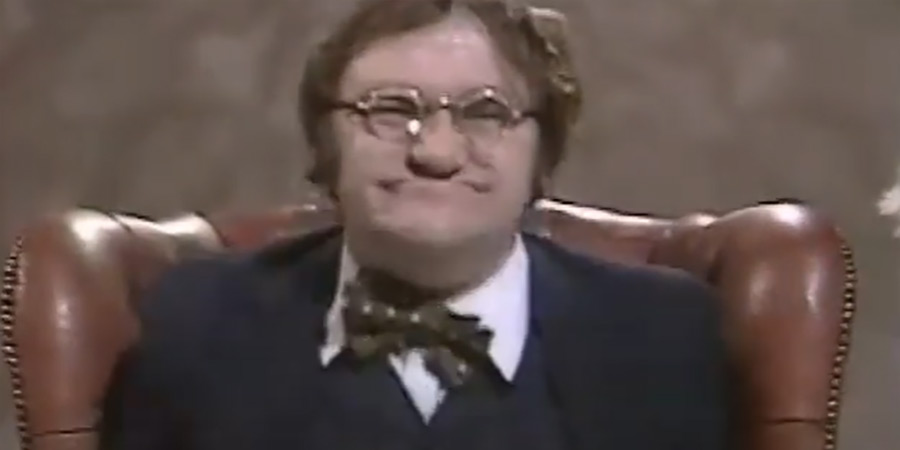 Les Dawson with round glasses on, gurning